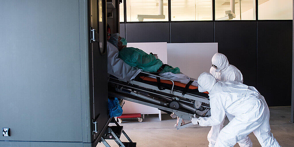 Das Tessin ist landesweit am stärksten vom Coronavirus betroffen: Soldaten der Schweizer Armee beim Transport eines Patienten mit Covid-19 am Eingang der Notaufnahme im Kantonsspital ''La Carita'' in Locarno. Das Tessin ist landesweit am stärksten vom Coronavirus betroffen: Soldaten der Schweizer Armee beim Transport eines Patienten mit Covid-19 am Eingang der Notaufnahme im Kantonsspital ''La Carita'' in Locarno.