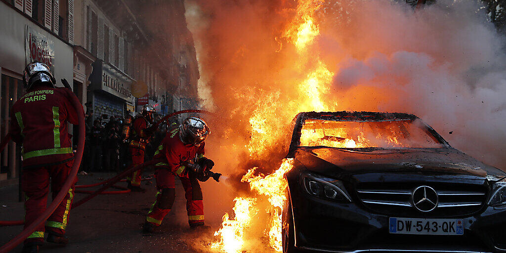 Die Feuerwehr löscht ein brennendes Auto in Paris. Foto: Francois Mori/AP/dpa Die Feuerwehr löscht ein brennendes Auto in Paris. Foto: Francois Mori/AP/dpa