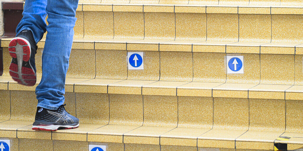 Ein Schüler geht während der Wiedereröffnung einer Sekundärschule in Brüssel eine Treppe mit Markierungen hinauf. Foto: Laurie Dieffembacq/BELGA/dpa