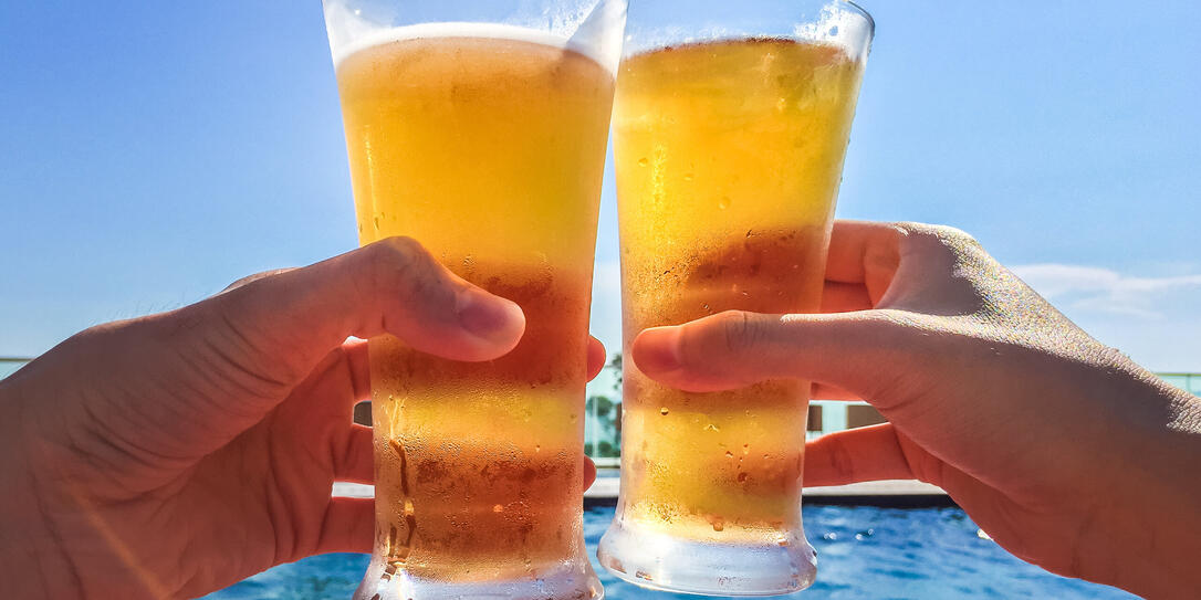 Hands Clinking Glasses of Beer by the pool Hands Clinking Glasses of Beer by the pool