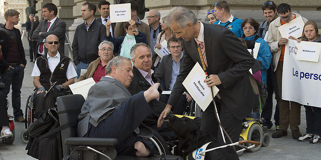 Nationalrat Christian Lohr (CVP/TG) und weitere Menschen mit Behinderungen bei einer Aktion vor dem Bundeshaus. Lohr fordert gemeinsam mit Behindertenverbänden Verbesserungen beim Assistenzbeitrag. (Archiv)