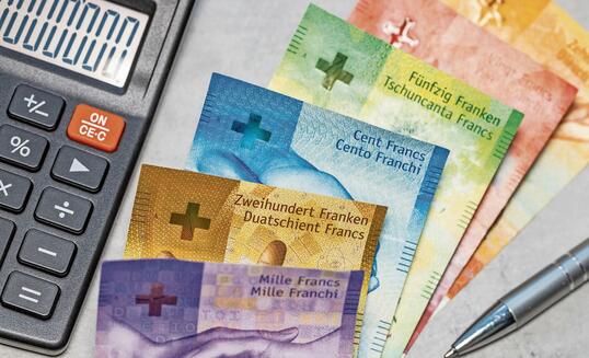 Switzerland money. Swiss francs on gray tabletop. Financial background. Banknotes and calculator. Swiss business concept. Copy space, close up. flat lay