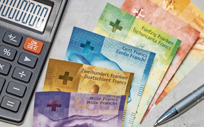 Switzerland money. Swiss francs on gray tabletop. Financial background. Banknotes and calculator. Swiss business concept. Copy space, close up. flat lay