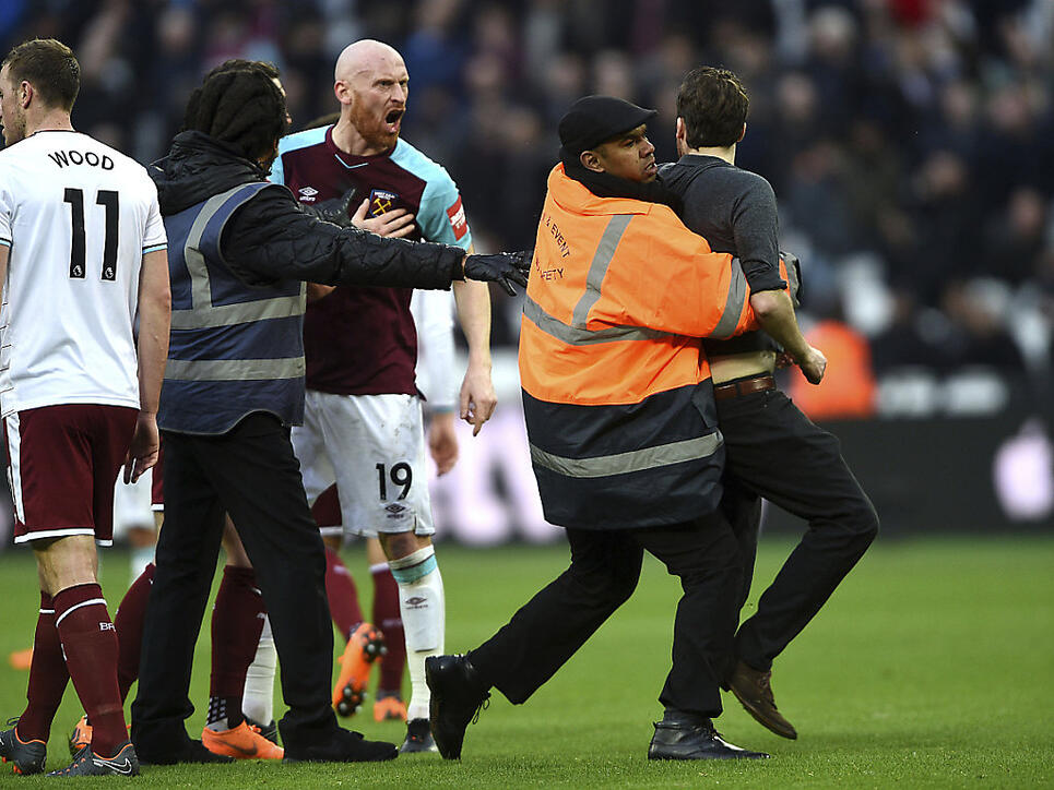 Ein auf den Platz gestürmter Fan legt sich mit West Hams Innenverteidiger James Collins an, ehe er abgeführt wird