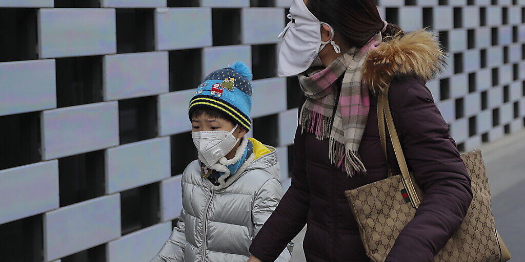 Die durch das Coronavirus hervorgerufene Lungenkrankheit aus China verbreitet sich weiter - überall auf der Welt schützen sich Menschen mittlerweile wie hier im Bild in Peking mit Schutzmasken.