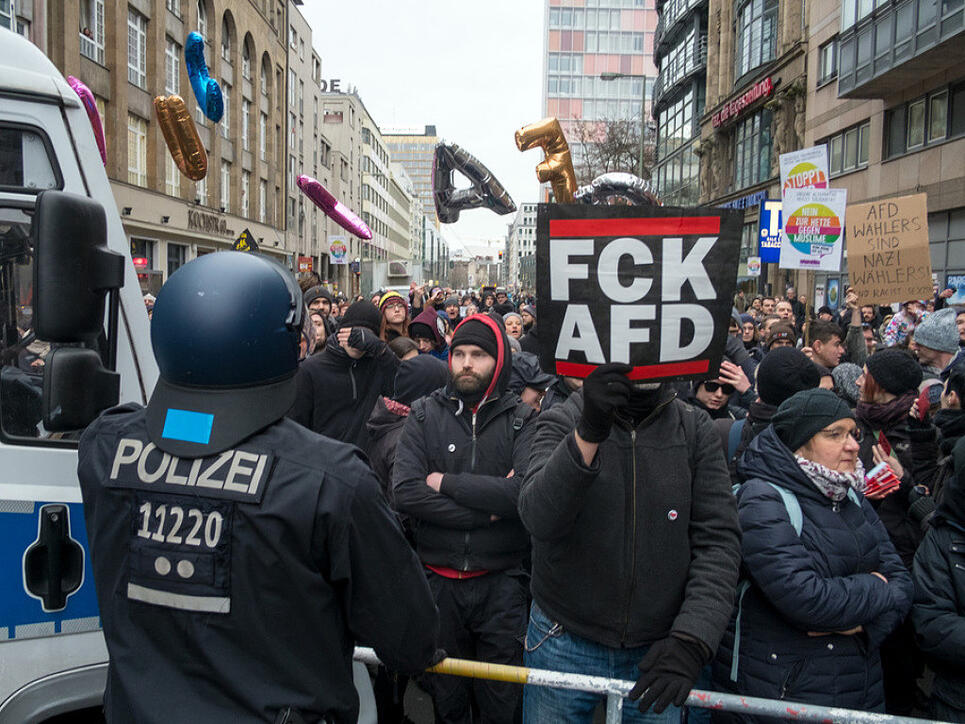 Polizisten blockieren in Berlin bei einem AfD-"Frauenmarsch" Gegendemonstranten am Checkpoint Charlie.