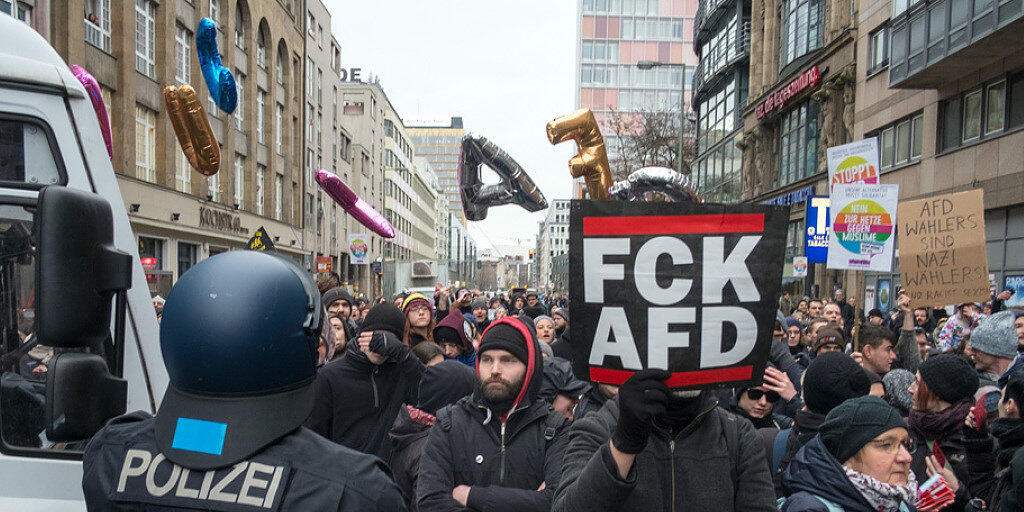 Polizisten blockieren in Berlin bei einem AfD-"Frauenmarsch" Gegendemonstranten am Checkpoint Charlie.