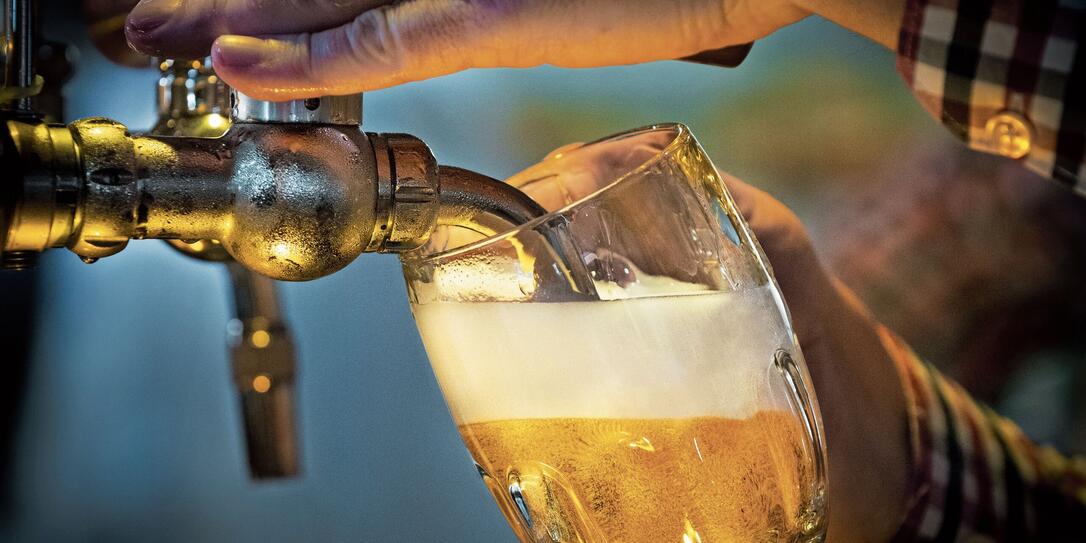 Male bartender pouring beer into glass