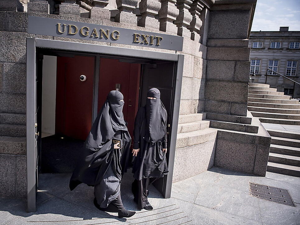 Zwei Nikab-tragende Frauen verlassen das dänische Parlament, nachdem dieses das Verbot der Vollverschleierung beschlossen hat. (Archiv)