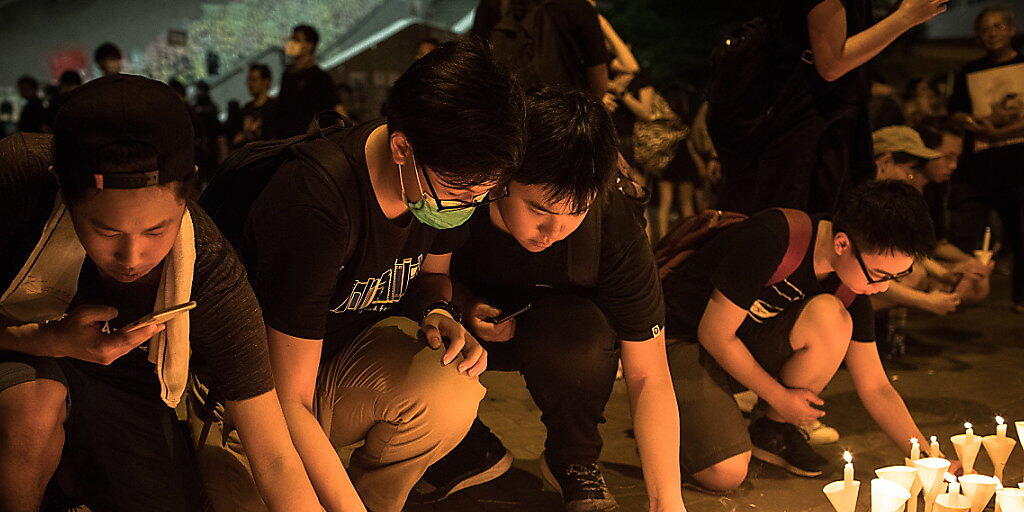Protestierende in Hongkong ehren das erste Todesopfer mit Kerzen.