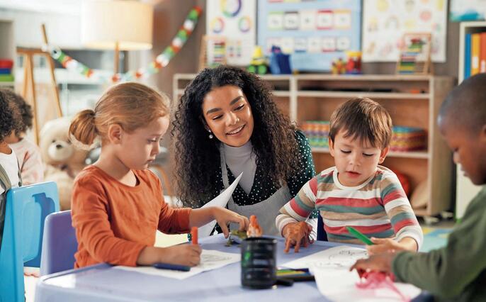 Drawing, education and teacher with children in classroom for learning, students and creative art. Growth, kindergarten and academy with woman and kids at school for helping and child development