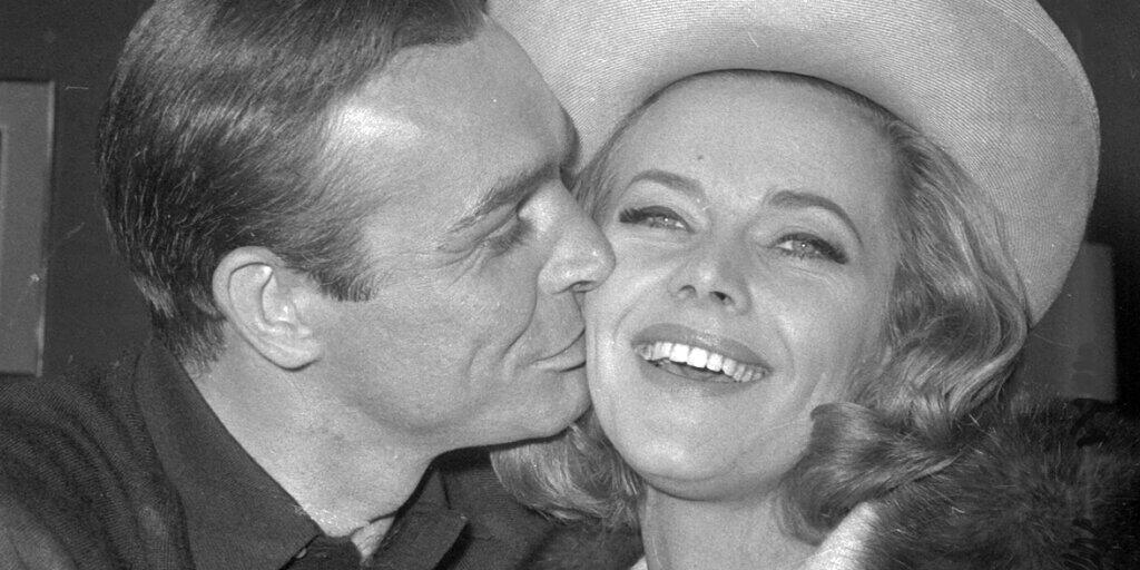 Sean Connery küsst Honor Blackman auf einer Party im März 1964 in den Pinewood Film Studios in Iver Heath, England.