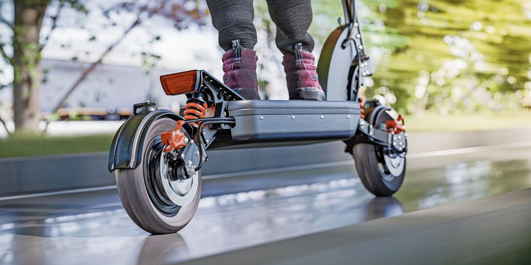 Electric scooter fast ride through the city - closeup to back wheel, motion blur effect
