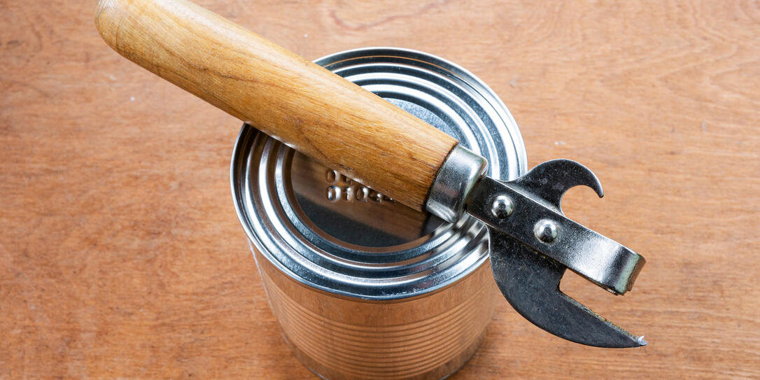 A canned food and a can opener close-up.