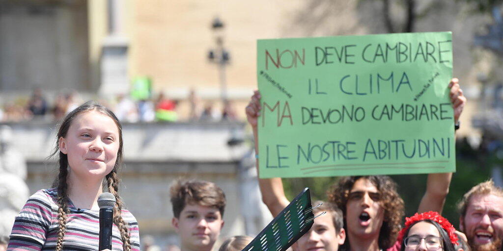 "Nicht das Klima muss sich ändern, aber unsere Gewohnheiten müssen es", halten Klima-Aktivisten in Rom in die Höhe, angeführt von der 16-jährigen Schwedin Greta Thunberg (links, mit Mikrophon).