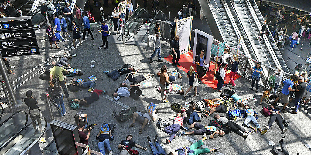 Menschen sollen auf dem Boden bleiben statt mit dem Flugzeug abzuheben: Kurz-Streik von Klimaaktivisten am Flughafen Zürich.