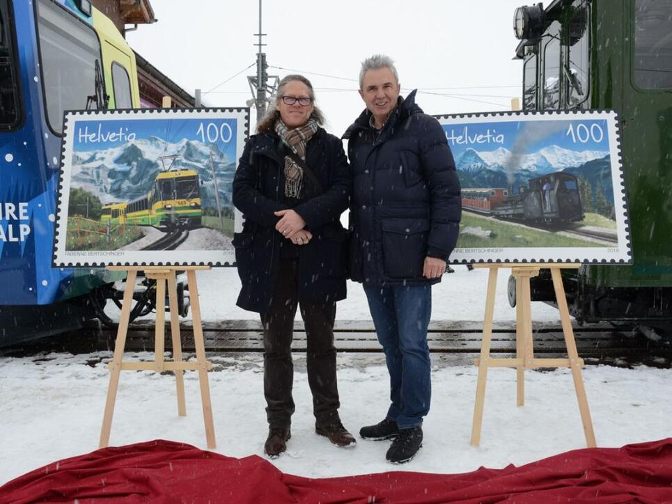 Urs Kessler (rechts), Chef der Jungfraubahnen, und Bernhard Kallen,  Leiter Produkt Management, enthüllen die Briefmarken der Wengernalpbahn und der Schynige Platte-Bahn zum 125 Jahr Jubiläum.