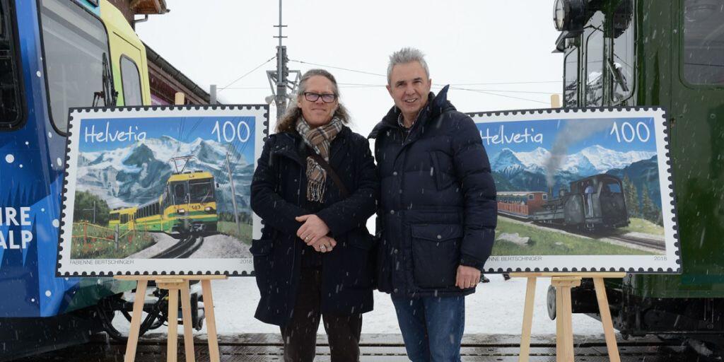 Urs Kessler (rechts), Chef der Jungfraubahnen, und Bernhard Kallen,  Leiter Produkt Management, enthüllen die Briefmarken der Wengernalpbahn und der Schynige Platte-Bahn zum 125 Jahr Jubiläum.