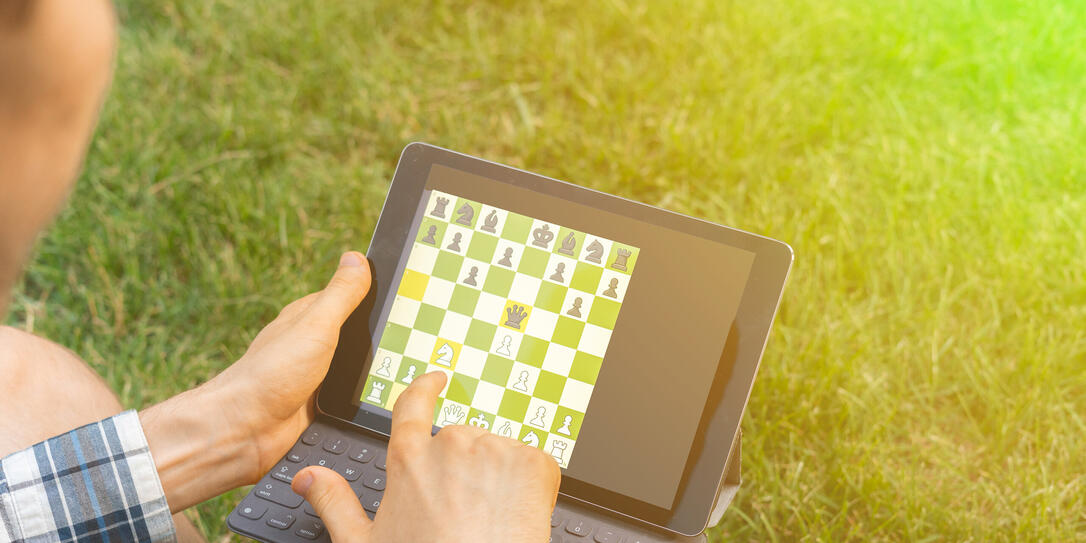 playing chess on a digital device outdoor, mental activity