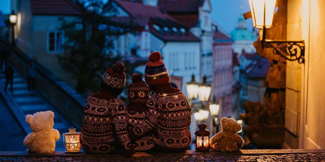 Beautiful children, three boy brothers, casually dressed, looking at night view of Prague city