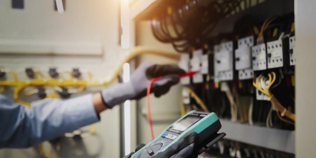 Electricity and electrical maintenance service, Engineer hand holding AC multimeter checking electric current voltage at circuit breaker terminal and cable wiring main power distribution board. Electricity and electrical maintenance service, Engineer hand holding AC multimeter checking electric current voltage at circuit breaker terminal and cable wiring main power distribution board.
