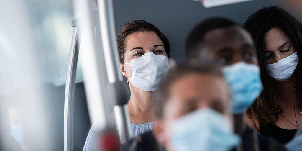 Passagiere mit Schutzmasken in einem Bus der Trasporti Pubblici Luganesi TPL am 6. Juli in Lugano. Seit diesem Datum müssen schweizweit alle Passagiere in den öffentlichen Verkehrsmitteln Schutzmasken gegen die Verbreitung des Coronavirus tragen. (Archivbild)