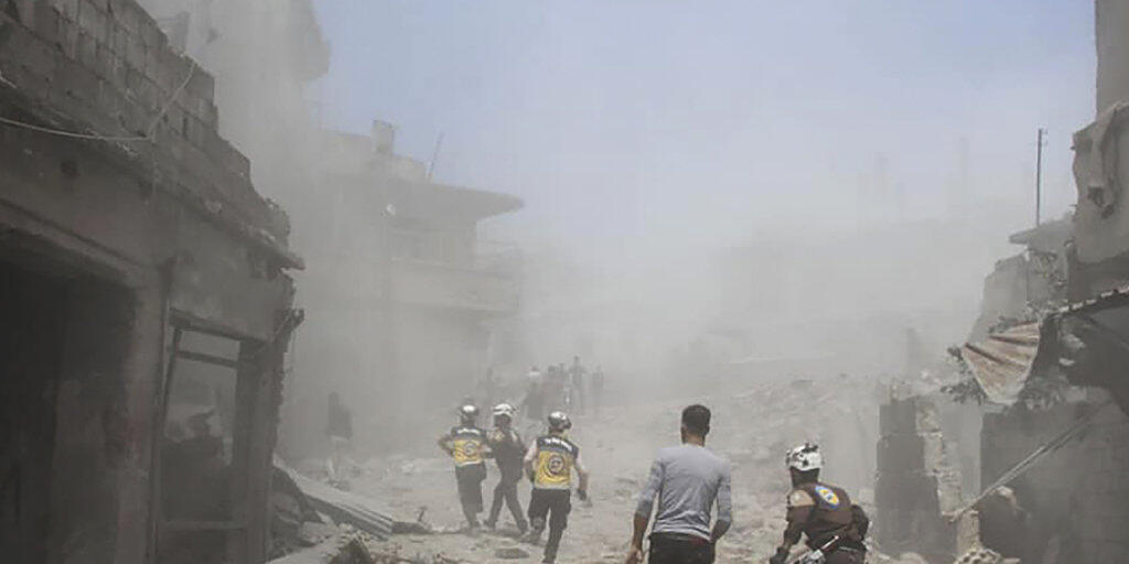 Mitarbeiter der Hilfsorganisation Weisshelme suchen nach einem Luftangriff in der Provinz Idlib nach Überlebenden. (Bild: Hilfsorganisation Weisshelme via AP/Keystone)