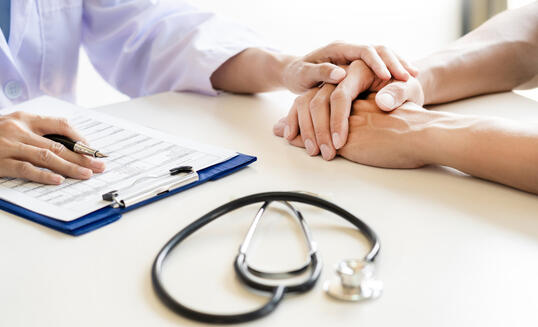 Midsection Of Doctor Consoling Patient In Hospital
