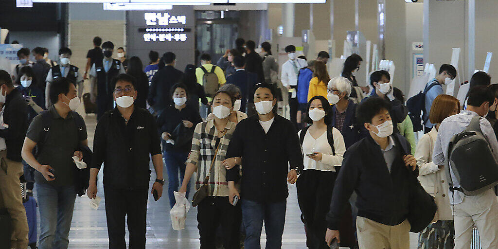 Menschen mit Mundschutz im Flughafen Gimpo in Seoul. Foto: Ahn Young-Joon/AP/dpa