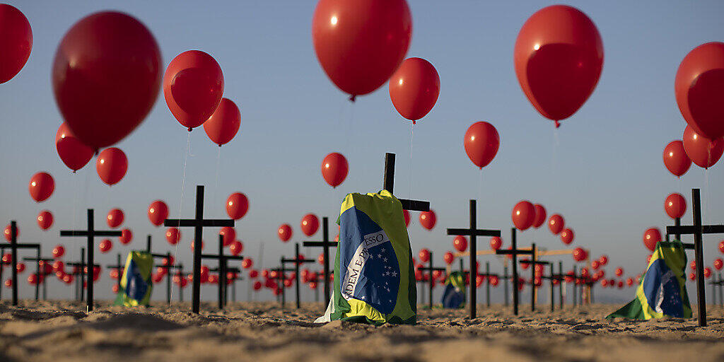 Die Nichtregierungsorganisation «Rio de Paz» platzierte zum Gedenken der Opfer der Covid-19-Pandemie 1000 rote Luftballons und 100 Kreuze am Strand der Copacabana. Die Zahl der Todesopfer des Coronavirus ist in Brasilien auf mehr als 100 000 gestiegen. Foto: Fernando Souza/dpa