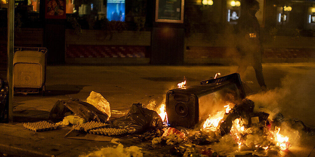 Ein Müllcontainer brennt in Madrid während eines Protests gegen die Ausgangssperre. Spanien ist eines der von der Corona-Krise am schwersten getroffenen Länder Westeuropas. Foto: Manu Fernandez/AP/dpa
