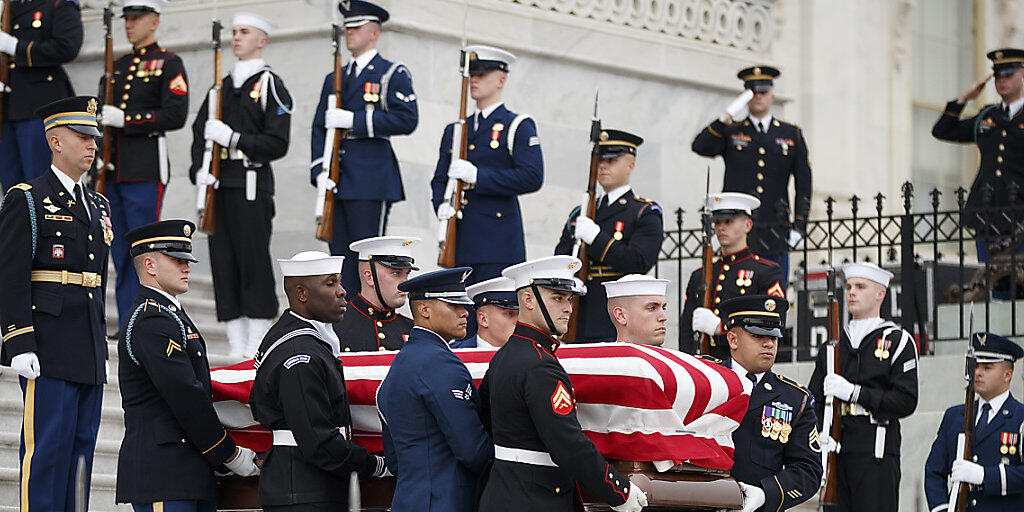 Der mit der US-Flagge bedeckte Sarg des verstorbenen US-Präsidenten George H. W. Bush wird unter militärischem Zeremoniell aus dem Kapitol herausgetragen.