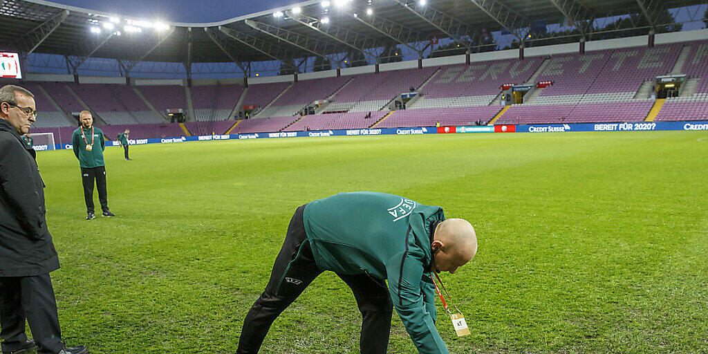 Schiedsrichter Szymon Marciniak inspiziert den durchnässten Platz im Stade de Genève und gibt grünes Licht für den Anpfiff um 20.45 Uhr
