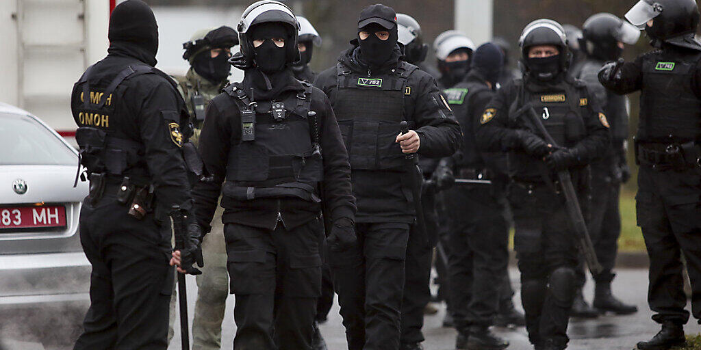 Bereitschaftspolizisten stehen am Rande eines Protests von Oppositionellen. Tausende Menschen haben trotz Polizeigewalt zum 15. Mal in Serie in Belarus bei einer Sonntagsdemonstration gegen den belarussischen Machthaber Lukaschenko friedlich protestiert. Foto: -/AP/dpa