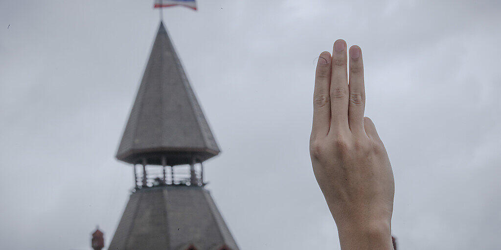ARCHIV - Ein pro-demokratischer Demonstrant erhebt während einer Demonstration im Sanam-Luang-Park drei Finger als Symbol des Widerstands. Foto: Wason Wanichakorn/AP/dpa