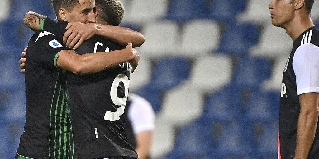 Sassuolos Torschützen Filip Djuricic (links) und Francesco Caputo feiern ihren Punktgewinn gegen Cristiano Ronaldos Juventus