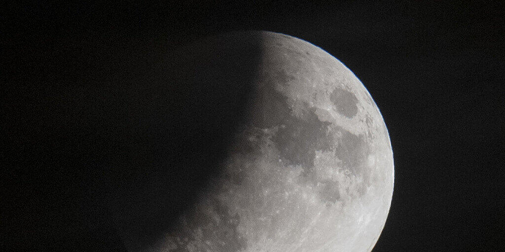 Eine partielle Mondfinsternis aufgenommen über den Dächern Zürichs.