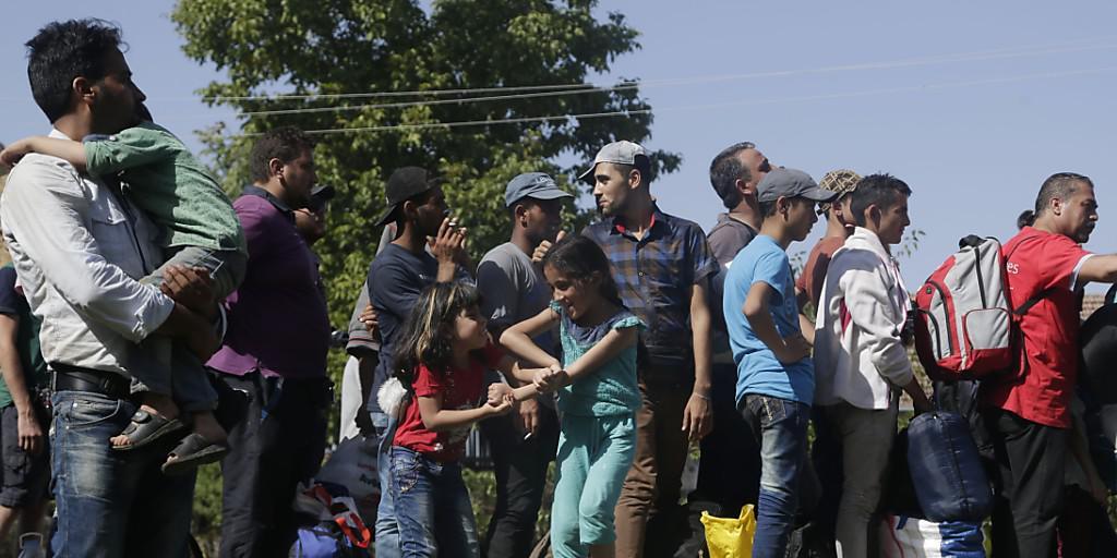 Flüchtlinge warten im kroatischen Ort Tovarnik auf einen Bus. Kroatien begann am Freitag, die Menschen per Bus nach Ungarn zu bringen.