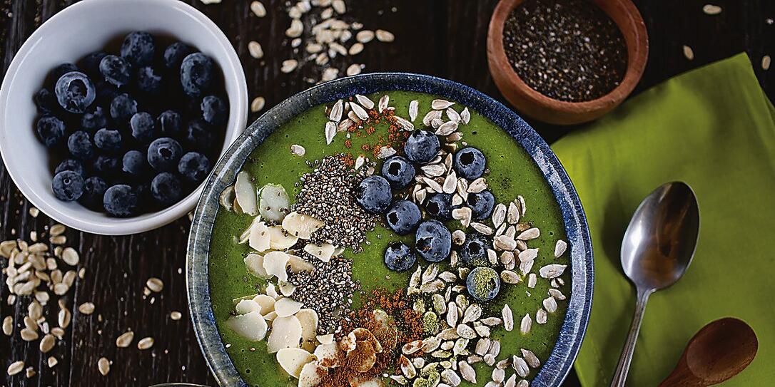 Green smoothie bowl with almonds, blueberries, chia and sunflower seeds