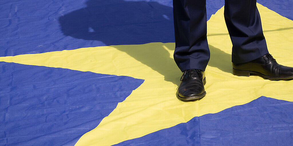 Die Beine eines Mannes auf einem Stern einer europäischen Flagge. Foto: Benoit Doppagne/BELGA/dpa