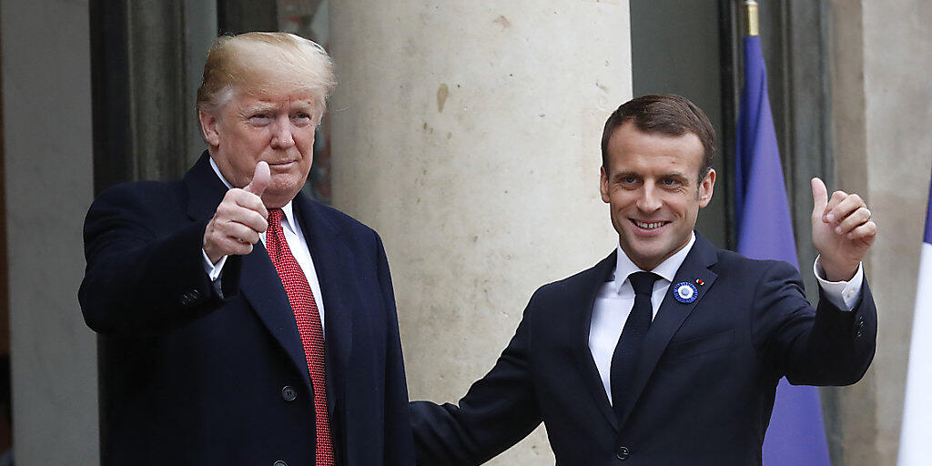 Lächeln vor den Kameras - nach bissigem Tweet: US-Präsident Trump (links) mit dem französischen Präsidenten Macron in Paris.
