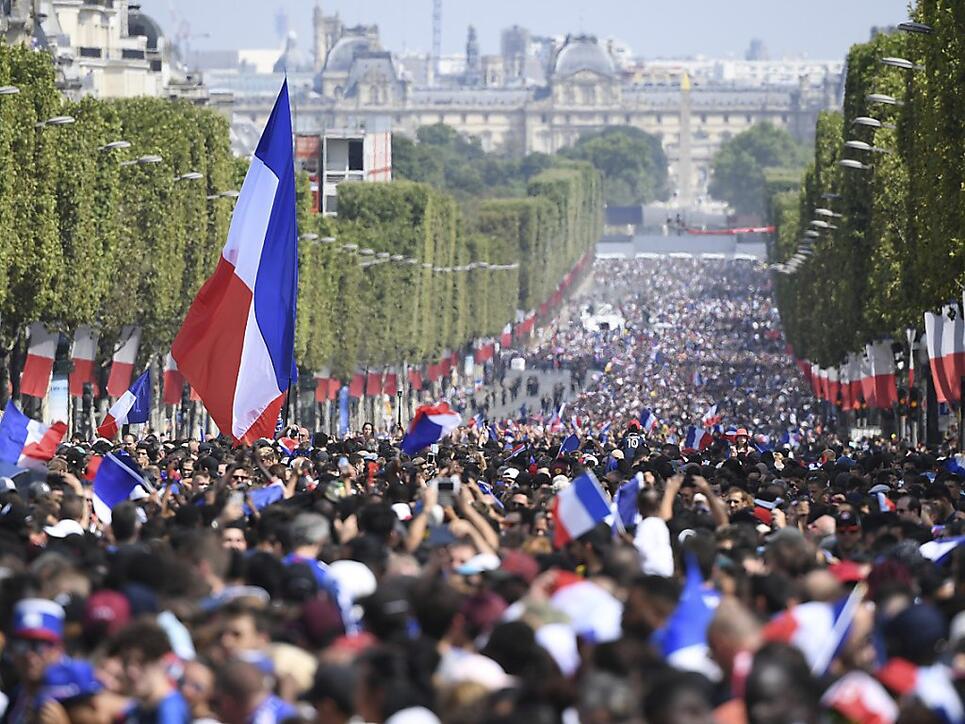 Auf deer Champs-Elysees warten Tausende von Fans auf ihre WM-Helden