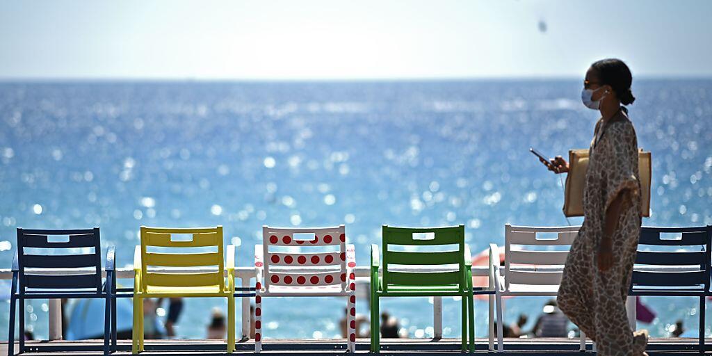 Eine Frau geht auf der Strandpromenade an der französischen Riviera an Stühlen vorbei. Foto: Anne-Christine Poujoulat/AFP/dpa Eine Frau geht auf der Strandpromenade an der französischen Riviera an Stühlen vorbei. Foto: Anne-Christine Poujoulat/AFP/dpa