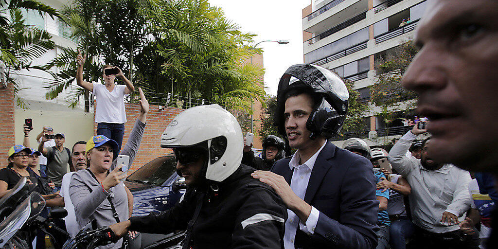 Oppositionsführer Juan Guaidó fährt auf dem Rücksitz eines Motorrads, nachdem er sich zuvor zum Staatspräsidenten erklärt hatte.