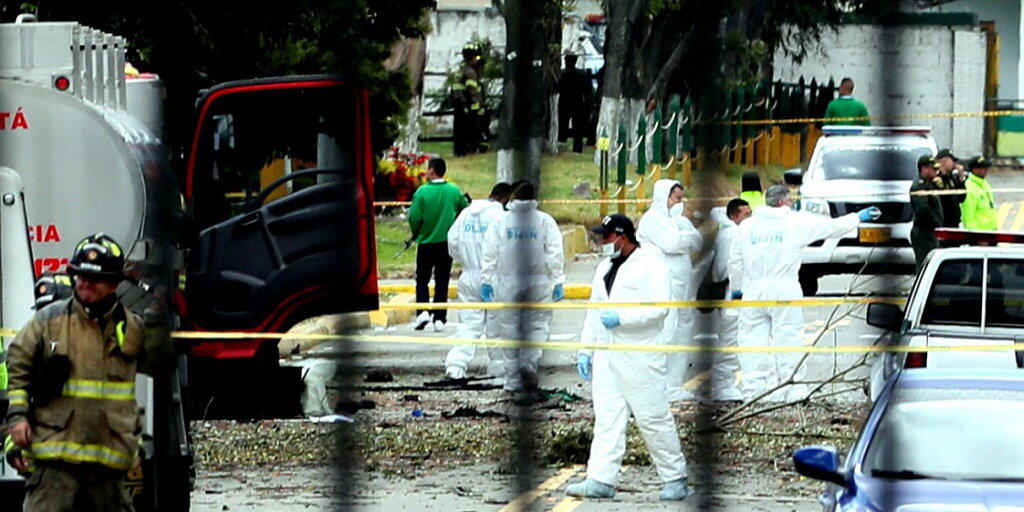 Spezialisten untersuchen den Tatort, nachdem bei einem Bombenanschlag auf eine Polizeischule in Bogotá acht Menschen getötet wurden.