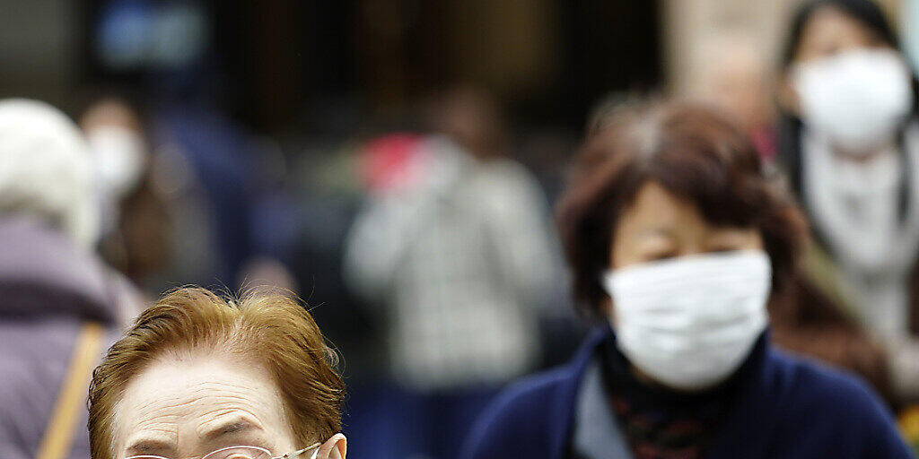 Menschen tragen Gesichtsmasken in einem Einkaufsviertel in Tokio. (Archivbild)