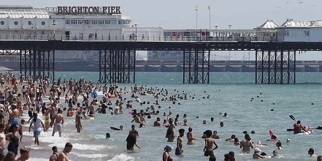 Menschen strömen bei schönem Wetter in Massen an den Strand von Brighton. Foto: Alastair Grant/AP/dpa