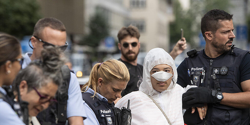 Polizisten führen am Montag Klimaaktivisten ab vor dem Eingang der Credit Suisse auf dem Paradeplatz in Zürich.