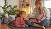 Mother and little daughter enjoying book together