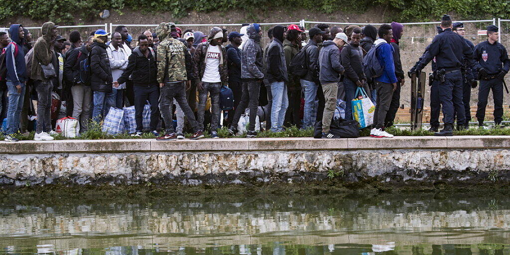 Flüchtlinge stehen Schlange, um in Unterkünfte in Paris oder der Umgebung gebracht zu werden. Seit Monaten hatten sich immer mehr Migranten an den Ufern zweier Kanäle im Nordosten der französischen Hauptstadt angesiedelt.